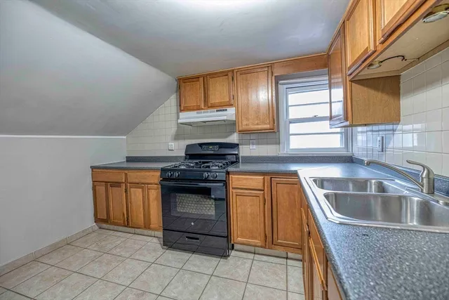 a kitchen with granite countertop a sink and a stove top oven