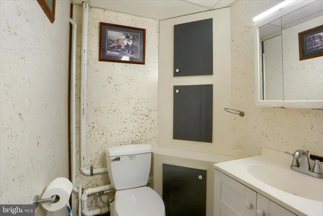 a bathroom with a toilet sink and mirror