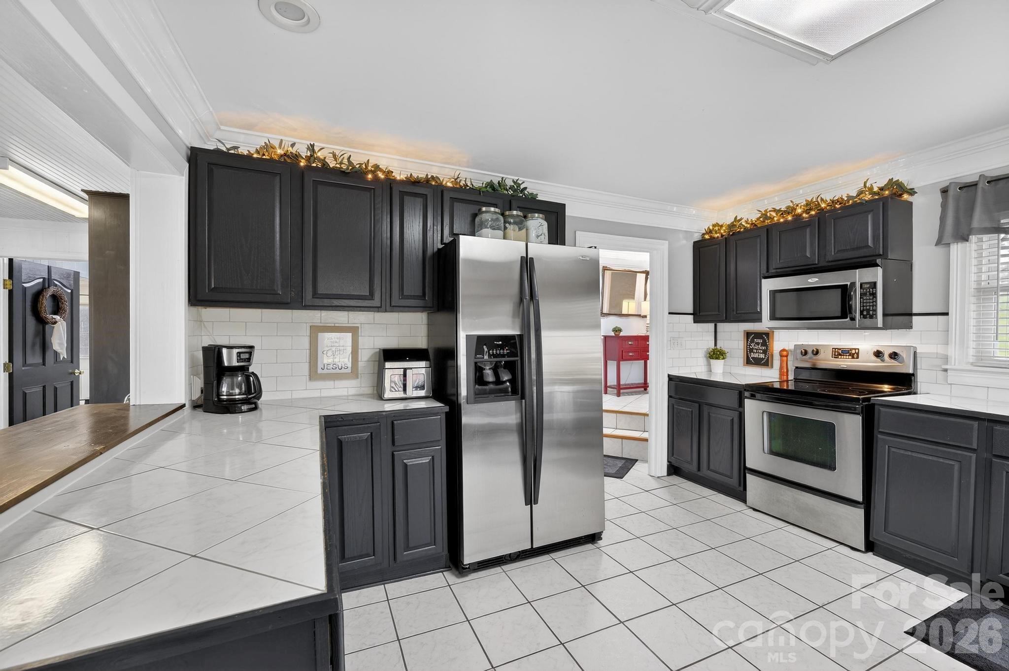 343 Hoyles Creek Road Dallas, NC 28034 - Photo 17 of 31 a kitchen with granite countertop a refrigerator and a stove top oven