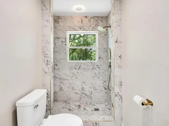 a bathroom with a toilet and a shower