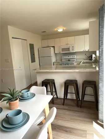 a kitchen with stainless steel appliances granite countertop a dining table and chairs