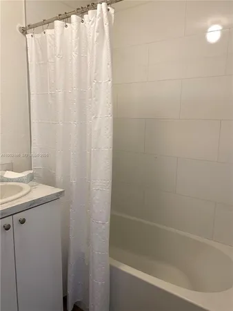 a bath room with a shower curtain and a sink