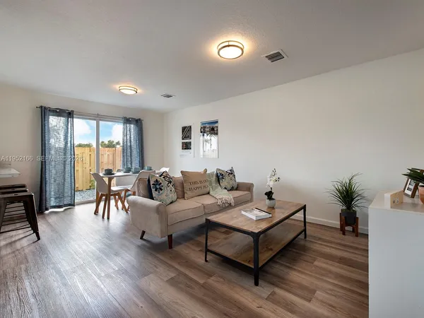 a living room with furniture and a wooden floor