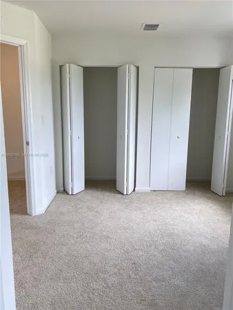 an empty room with closet and mirror