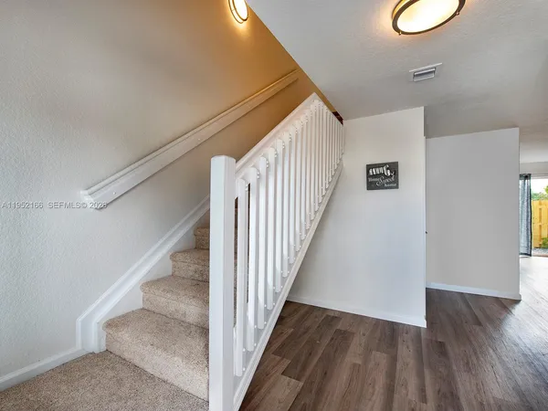 a view of a hallway with wooden floor and entryway