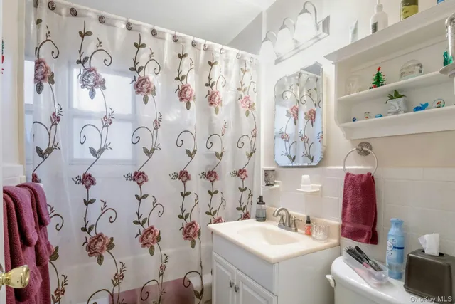 a bathroom with a sink and mirror with toilet