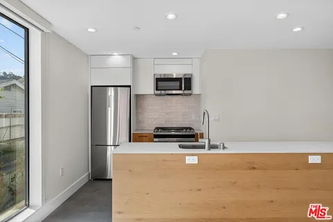 a kitchen with stainless steel appliances a refrigerator and a stove top oven