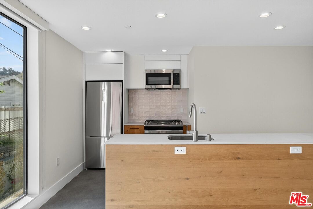 2412 Eads Street, Unit 7 Los Angeles, CA 90031 - Photo 11 of 29 a kitchen with stainless steel appliances a refrigerator and a stove top oven