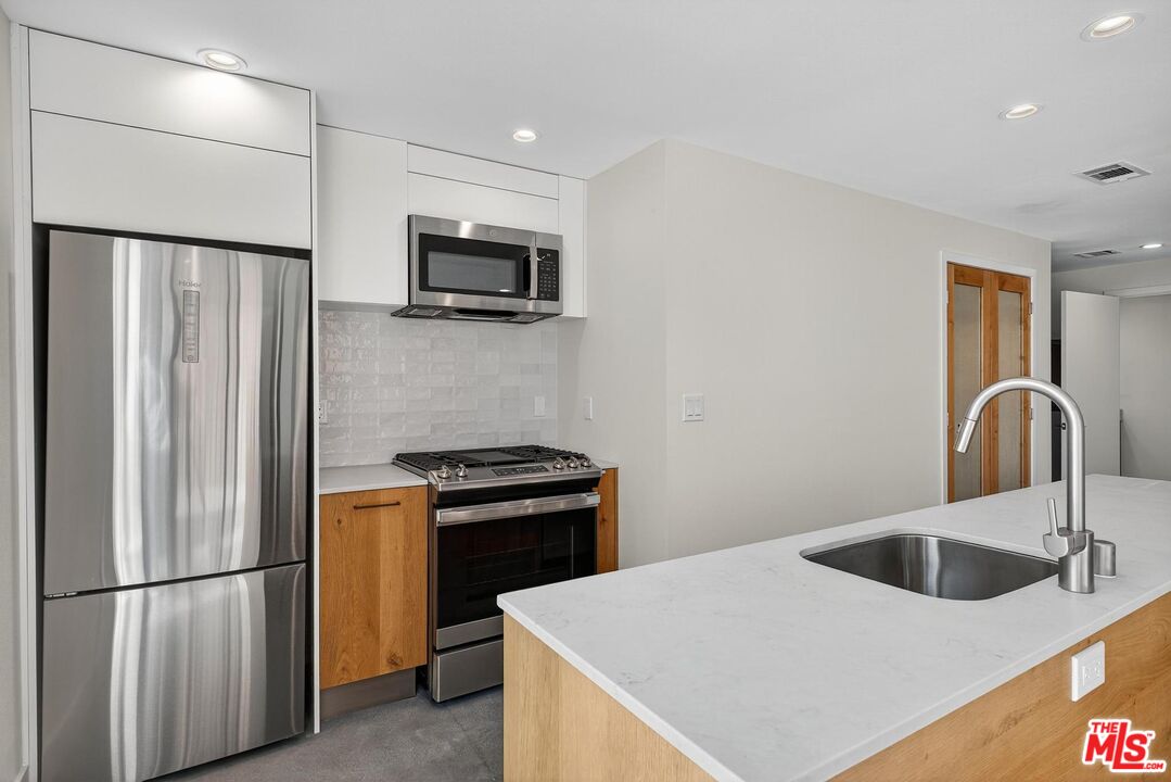 2412 Eads Street, Unit 7 Los Angeles, CA 90031 - Photo 12 of 29 a kitchen with stainless steel appliances granite countertop a refrigerator a stove a sink and a microwave