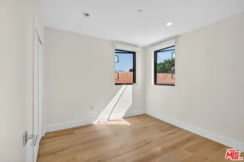 an empty room with wooden floor and a window