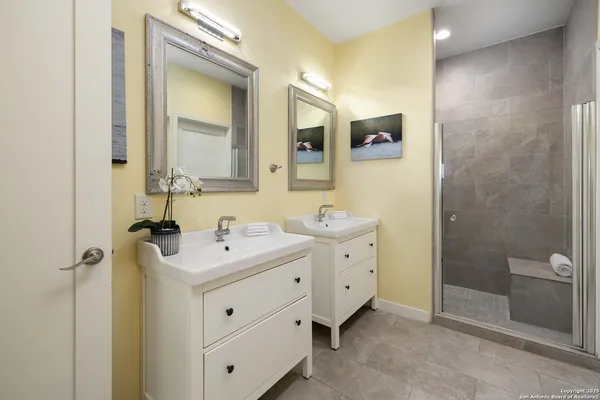 a bathroom with a double vanity sink mirror and shower