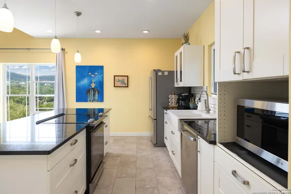 a kitchen with stainless steel appliances granite countertop a sink and a stove
