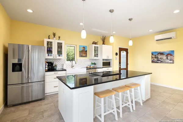 a kitchen with stainless steel appliances granite countertop a refrigerator a sink and a stove