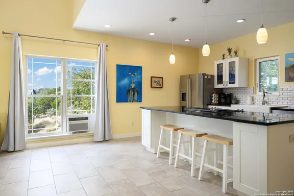 a large kitchen with granite countertop a large counter top space and stainless steel appliances