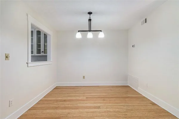 a view of empty room with wooden floor and ceiling fan