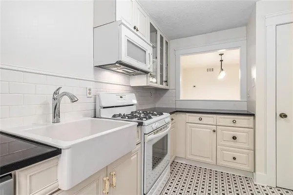 a kitchen with a sink stove and cabinets