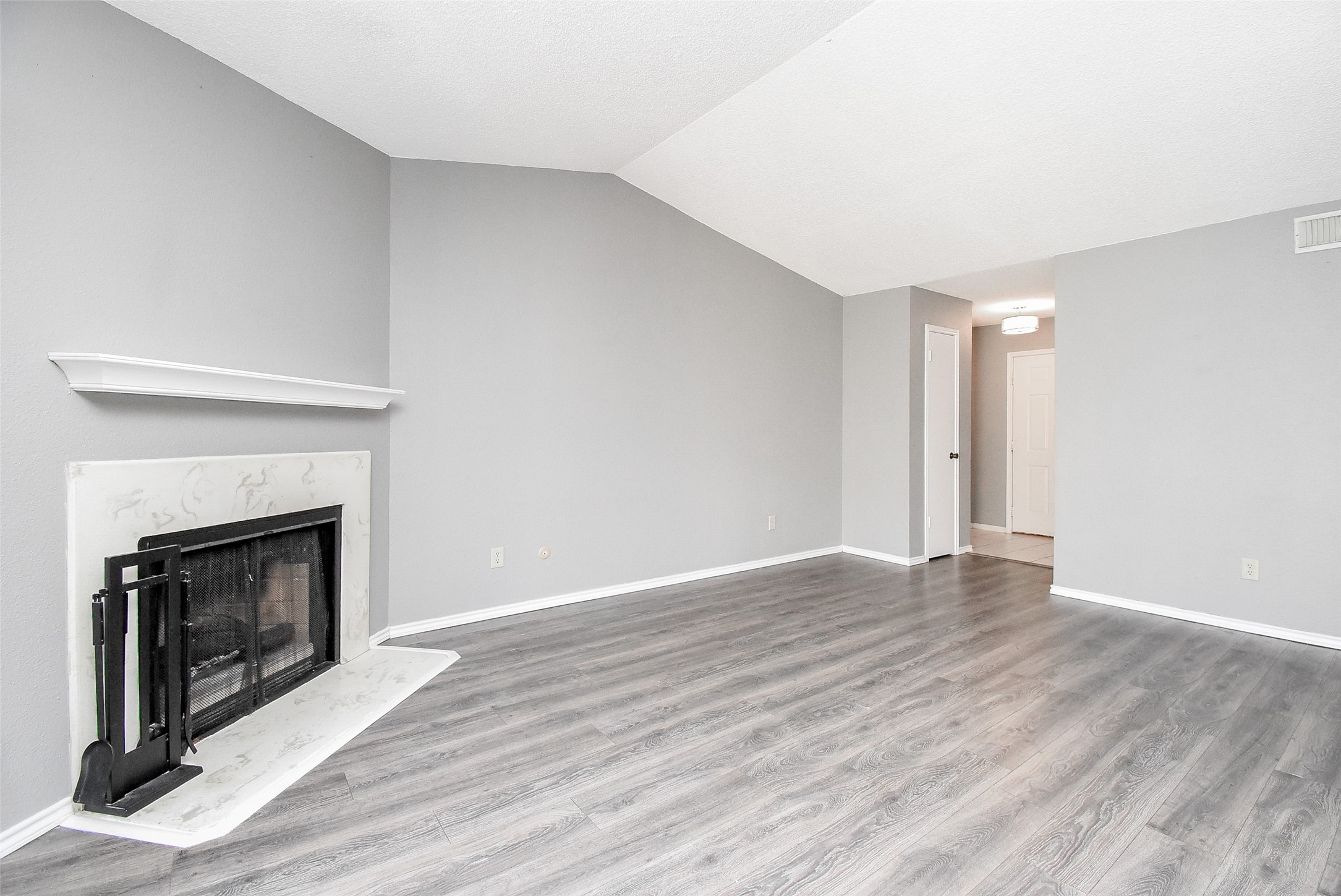 1515 Sandy Springs Road, Unit 1006 Houston, TX 77042 - Photo 2 of 35 a view of an empty room with wooden floor fireplace and a window