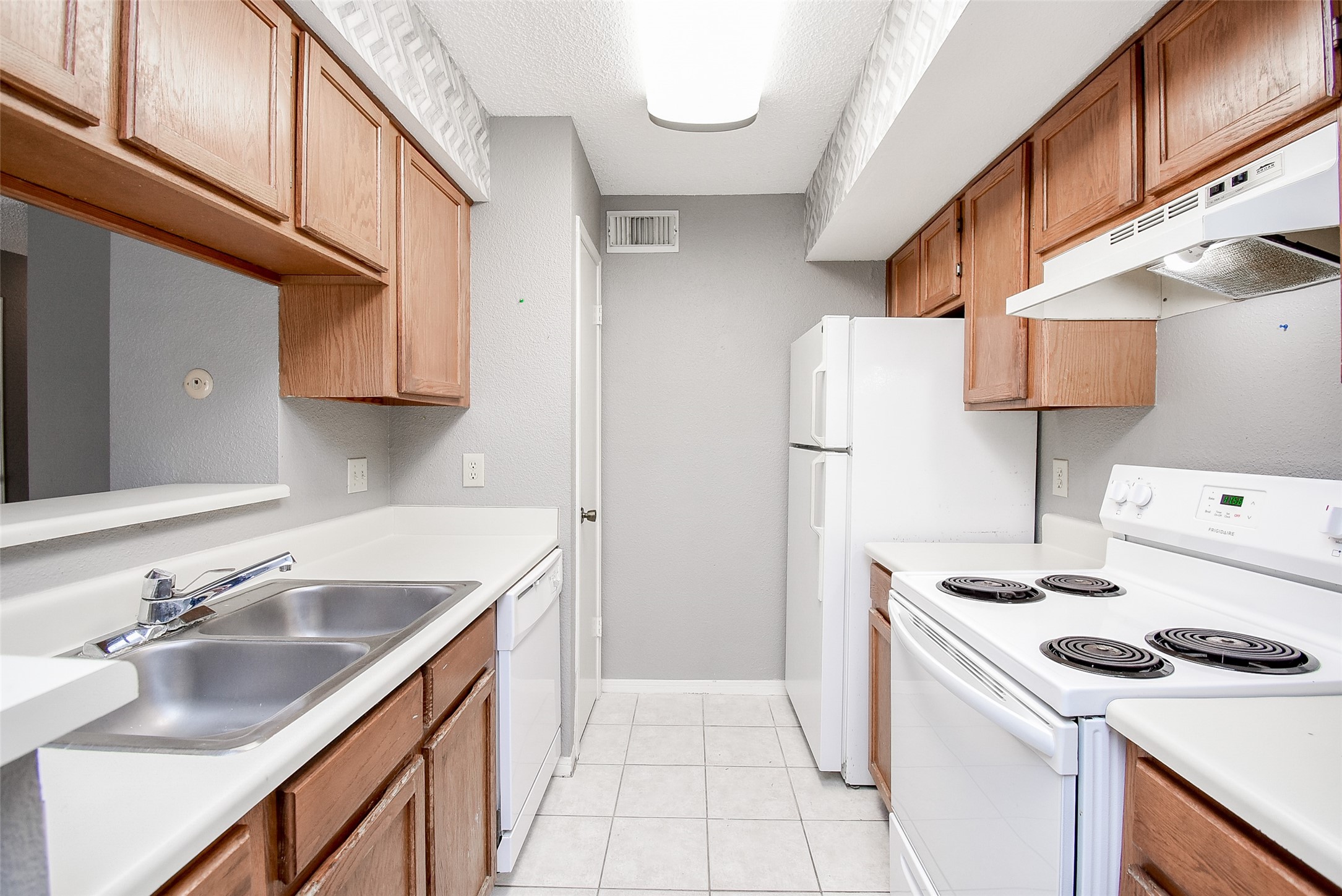 1515 Sandy Springs Road, Unit 1006 Houston, TX 77042 - Photo 8 of 35 a kitchen with a sink a stove and refrigerator