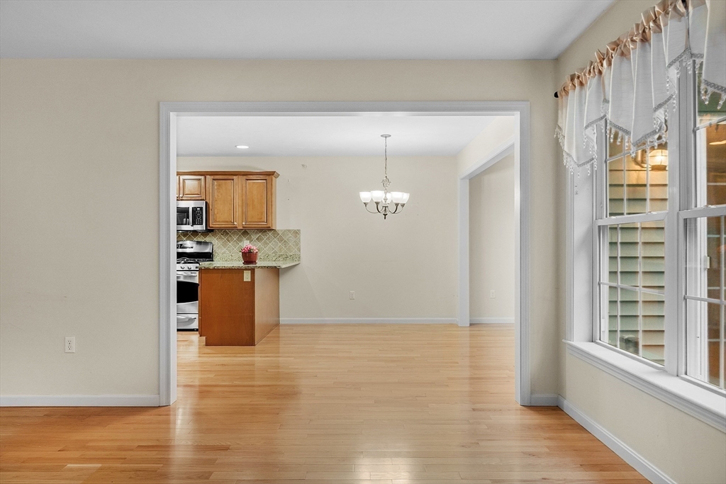 2 Riley Road, Unit C Lunenburg, MA 01462 - Photo 15 of 42 a view of a kitchen with kitchen island a sink wooden floor and a large window