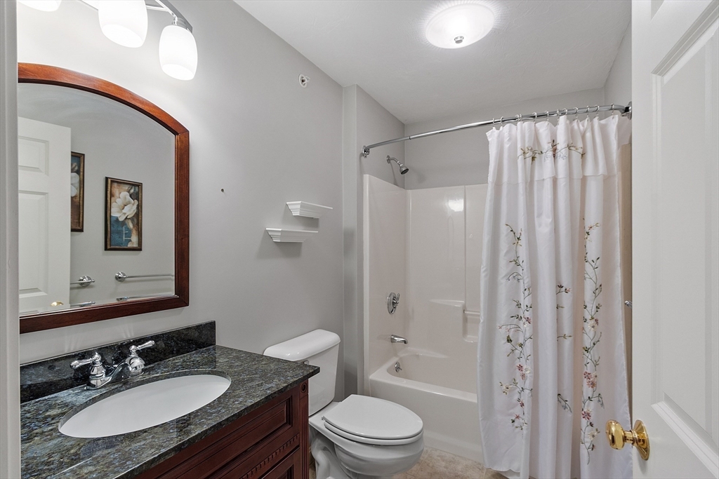 2 Riley Road, Unit C Lunenburg, MA 01462 - Photo 20 of 42 a bathroom with a granite countertop sink toilet a mirror a vanity and shower