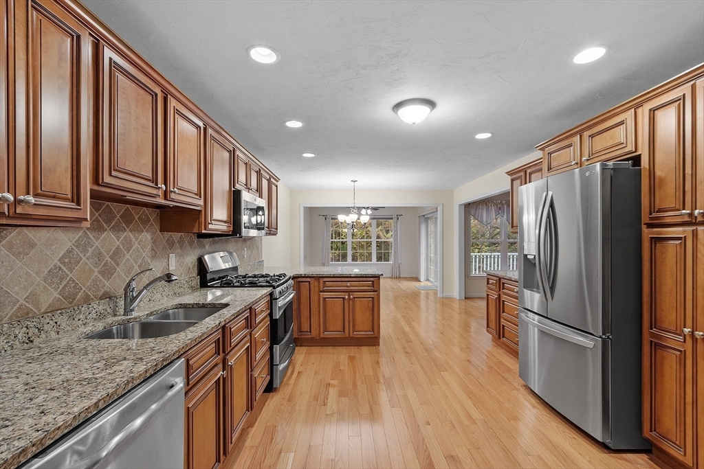 2 Riley Road, Unit C Lunenburg, MA 01462 - Photo 21 of 42 a kitchen with granite countertop stainless steel appliances a refrigerator cabinets and wooden floor