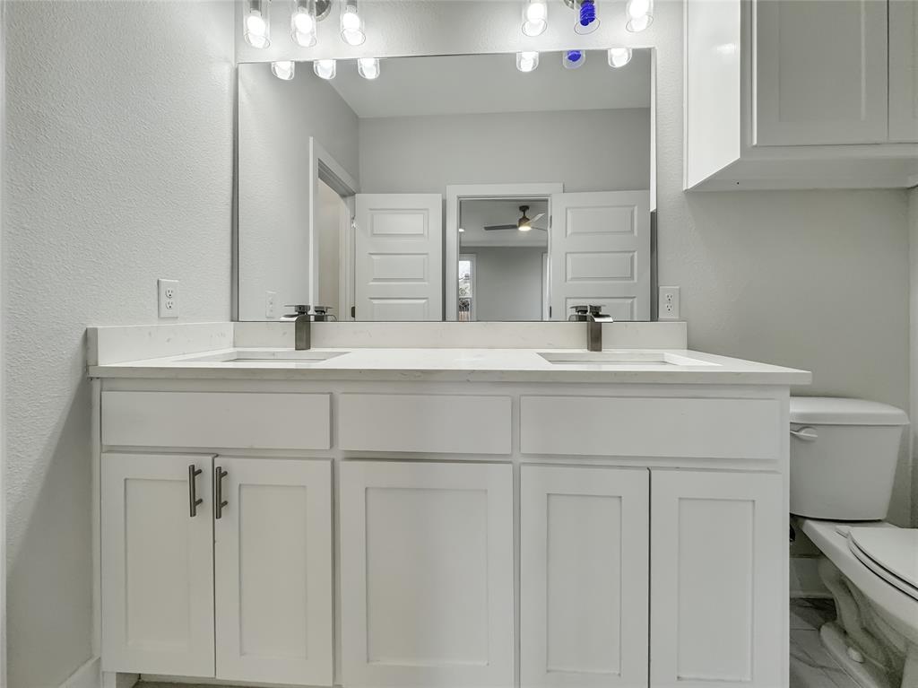 3518 Meadow Street Dallas, TX 75215 - Photo 19 of 20 Full bath featuring double vanity, marble look tile flooring, a textured wall, and a ceiling fan