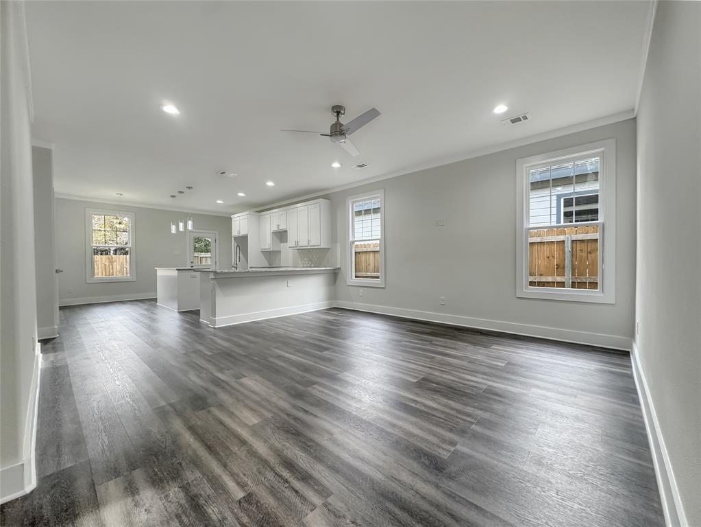 3518 Meadow Street Dallas, TX 75215 - Photo 3 of 20 Unfurnished living room featuring ornamental molding, recessed lighting, a ceiling fan, dark wood-type flooring, and a chandelier