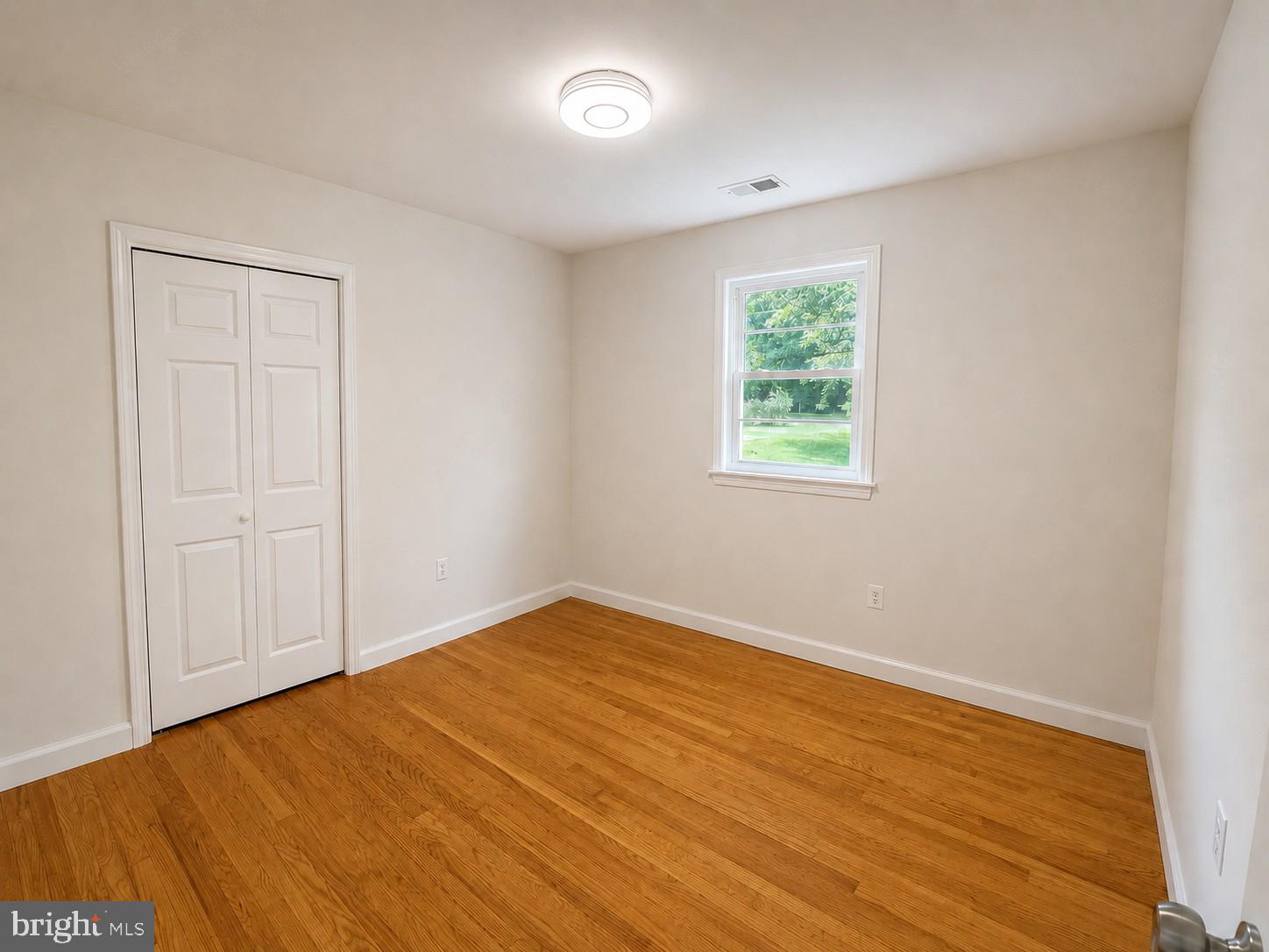 12658 Scaggsville Road Highland, MD 20777 - Photo 4 of 13 a view of an empty room with wooden floor and a window