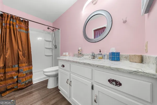 a bathroom with a granite countertop toilet sink and mirror
