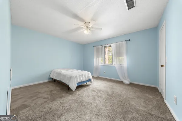 a bed sitting in a bedroom next to a window