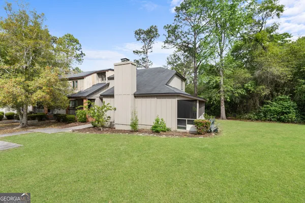 a front view of a house with a yard and trees