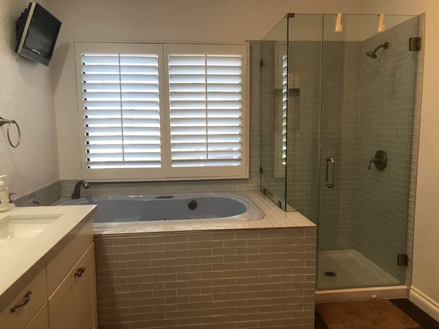 a spacious bathroom with double vanity sink a mirror and a bathtub
