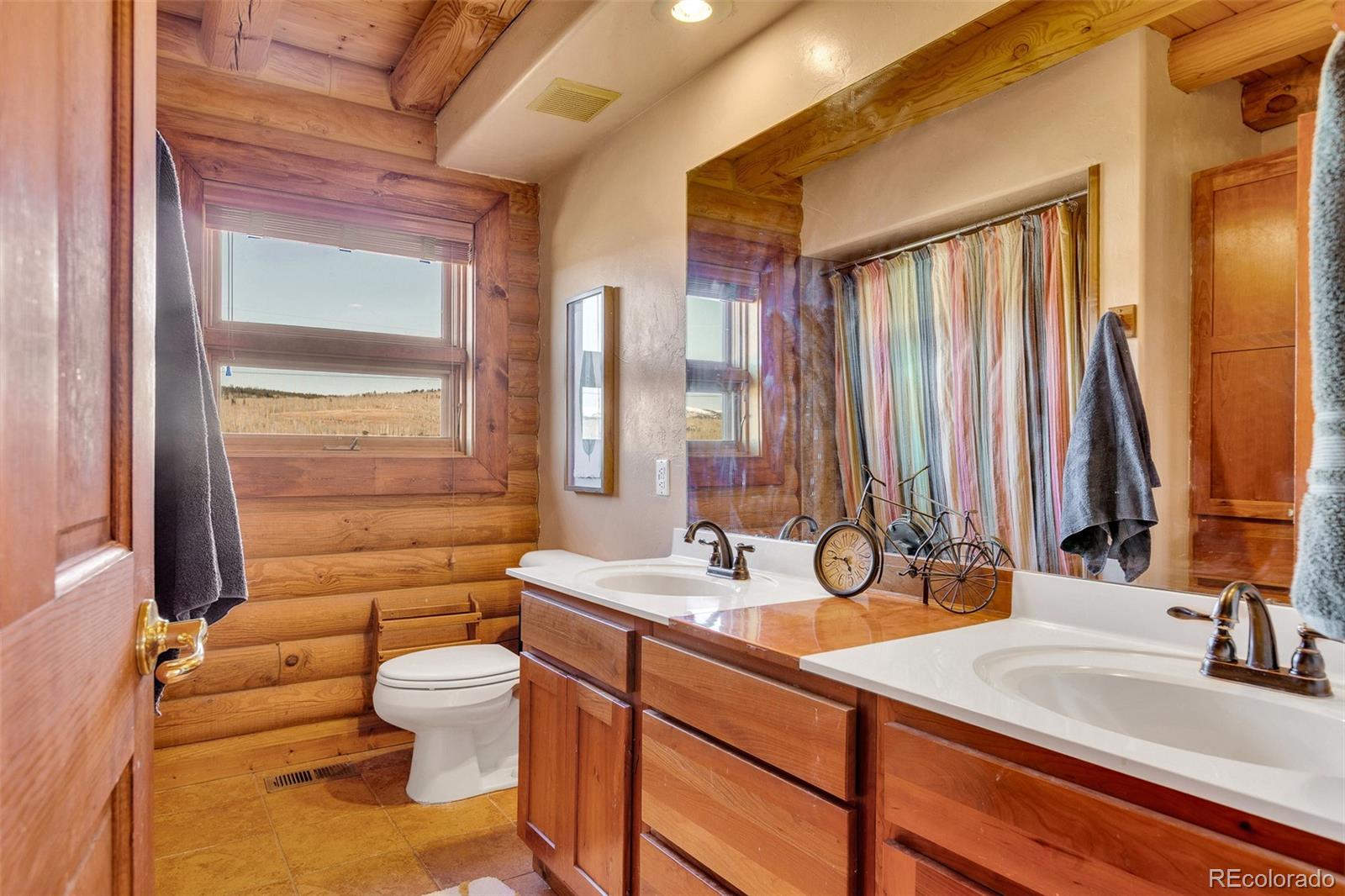 1528 Silver Heels Road Fairplay, CO 80440 - Photo 20 of 50 a bathroom with a double vanity sink toilet and a tub