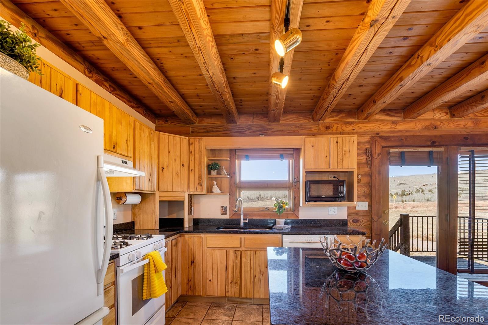 1528 Silver Heels Road Fairplay, CO 80440 - Photo 8 of 50 a view of a kitchen with granite countertop a couch wooden floor and a dining table