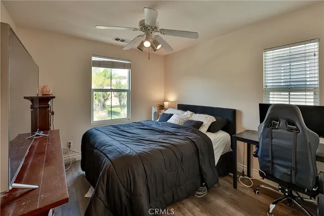 a bedroom with a bed tv and a window