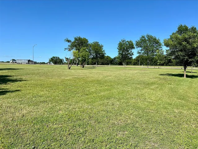 a view of a field with an trees in the background