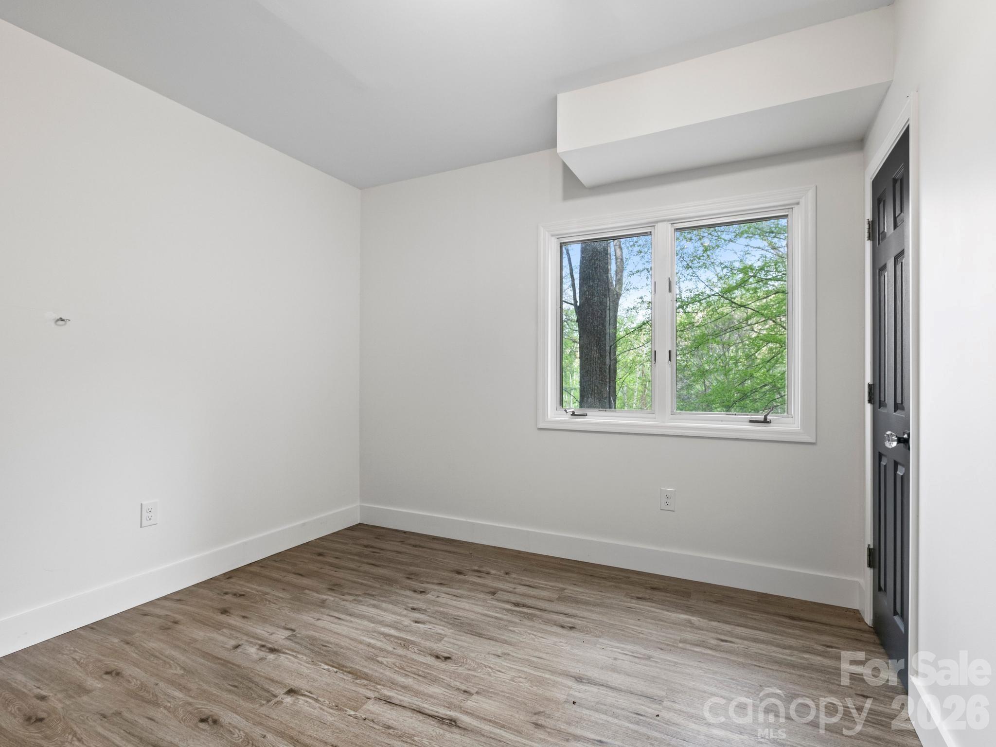 291 Webb Cove Road Asheville, NC 28804 - Photo 24 of 34 an empty room with wooden floor and windows