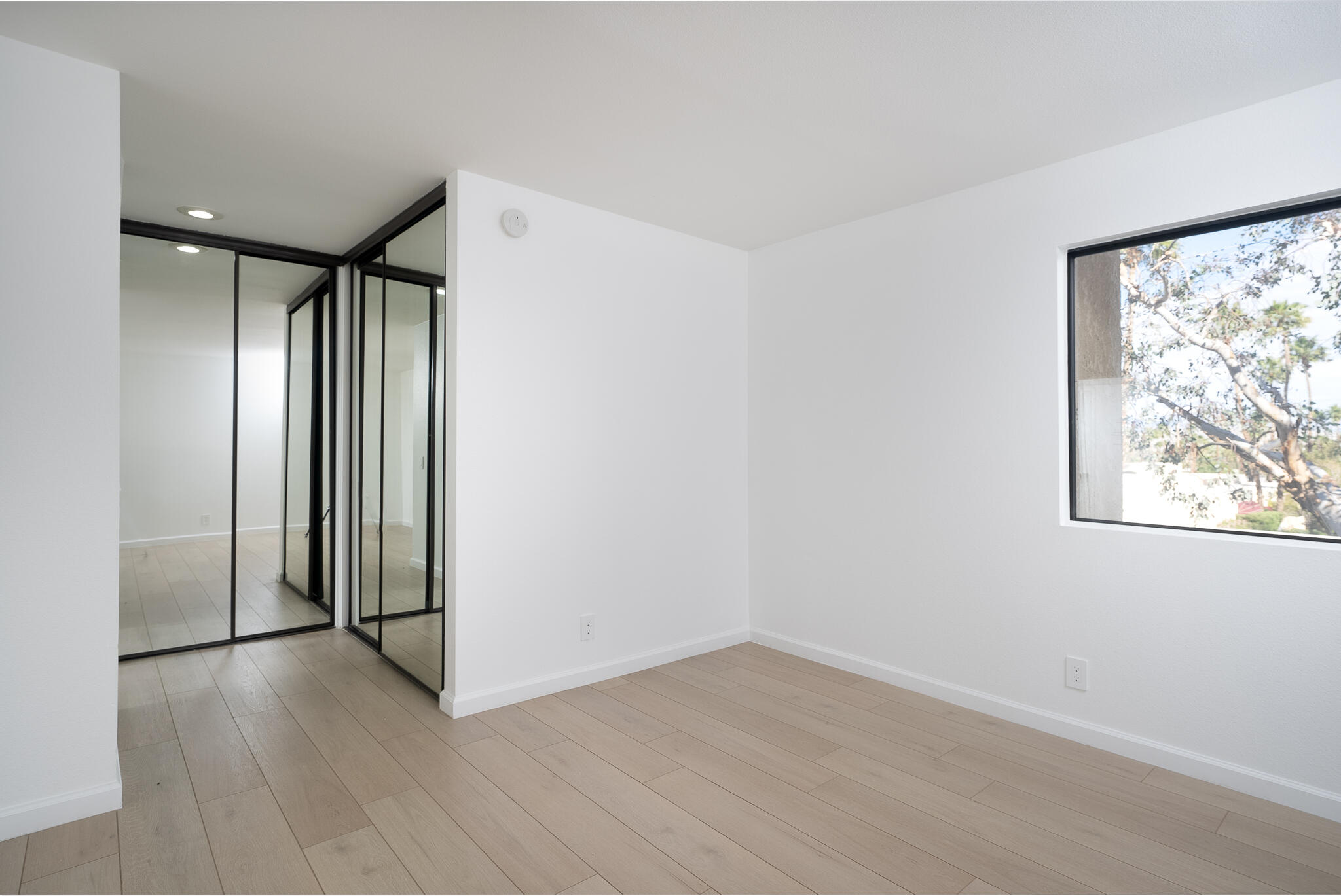 200 East Racquet Club Road, Unit 24 Palm Springs, CA 92262 - Photo 33 of 58 an empty room with wooden floor and windows