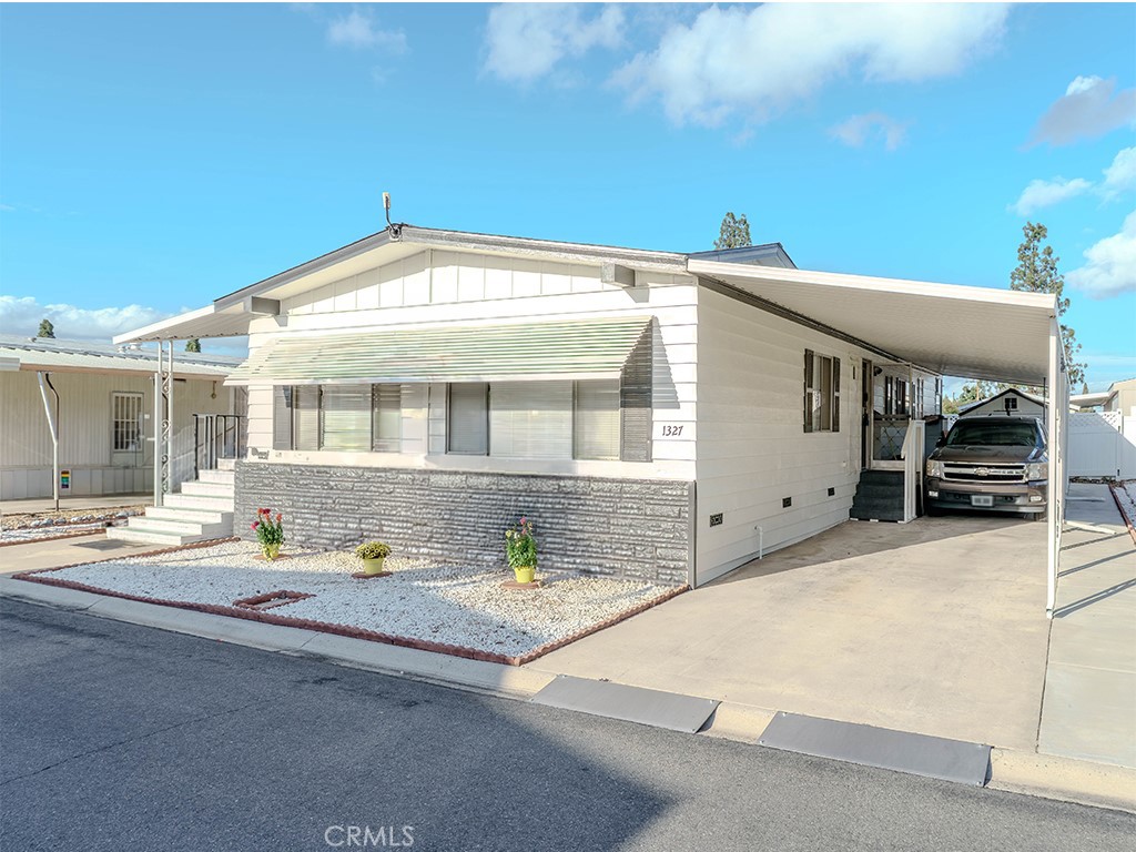 1327 Woodbrook Square Corona, CA 92882 - Photo 2 of 21 a front view of a house with a yard and seating space