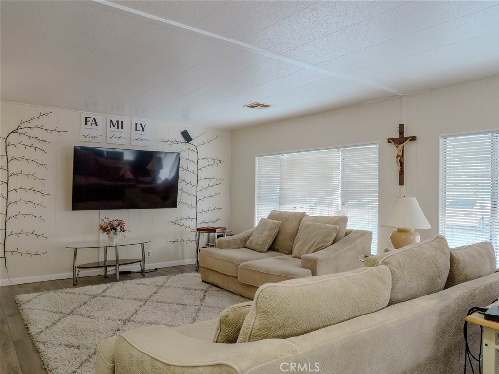 1327 Woodbrook Square Corona, CA 92882 - Photo 5 of 21 a living room with furniture and a flat screen tv