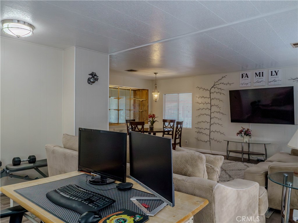 1327 Woodbrook Square Corona, CA 92882 - Photo 6 of 21 a living room with furniture and a flat screen tv