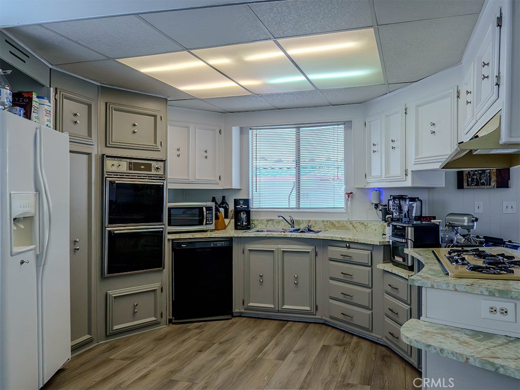 1327 Woodbrook Square Corona, CA 92882 - Photo 7 of 21 a kitchen with stainless steel appliances granite countertop a refrigerator and a stove top oven