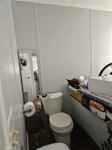 a bathroom with a granite countertop toilet sink and mirror