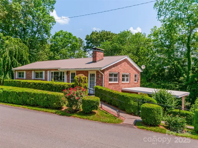 a front view of a house with a yard and potted plants