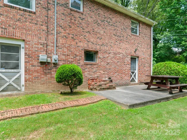 a view of a backyard with table and chairs potted plants and a wooden bench