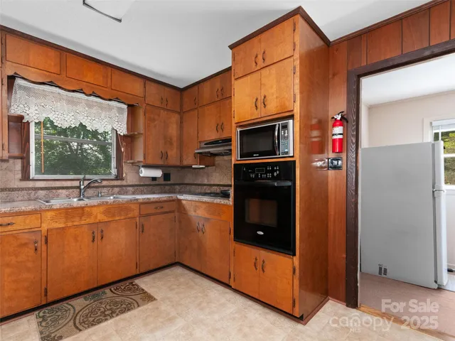 a kitchen with stainless steel appliances granite countertop a refrigerator and a sink