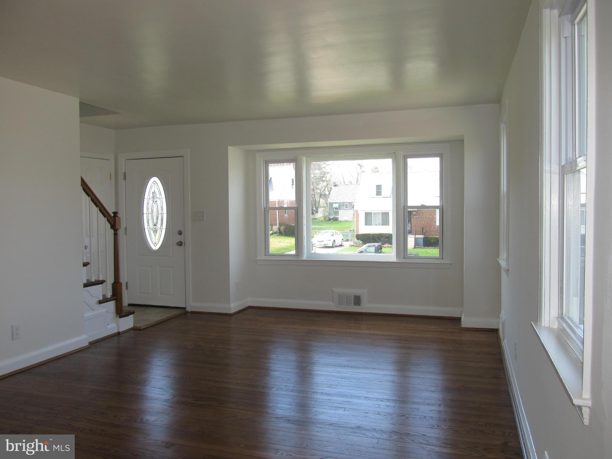 3507 Mayfair Road Baltimore, MD 21207 - Photo 3 of 30 an empty room with wooden floor and windows