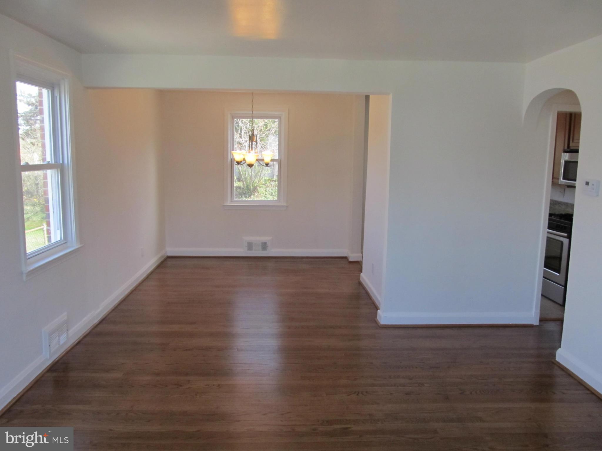 3507 Mayfair Road Baltimore, MD 21207 - Photo 4 of 30 an empty room with wooden floor and windows