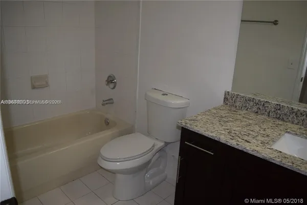 a bathroom with a granite countertop toilet a sink and bathtub