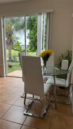 a living room with a table chair and a large window